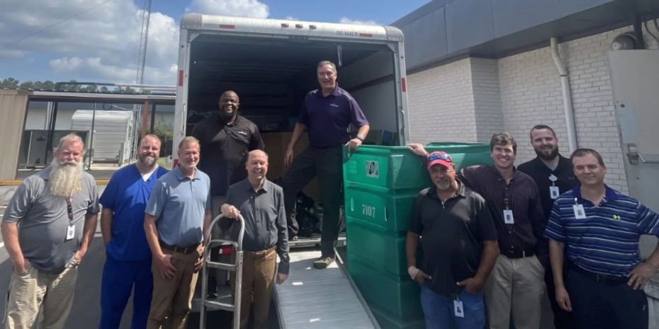 A group of people standing in front of a truck.