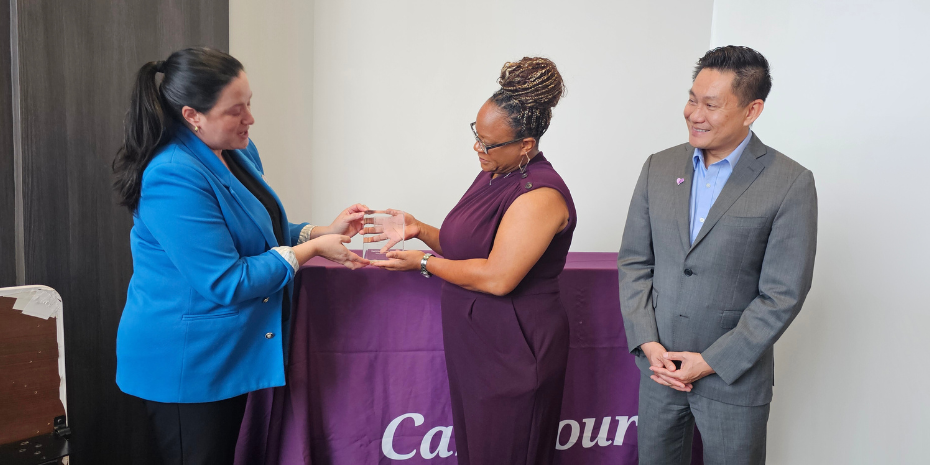 Woman handing award to two CareSource leadership team members